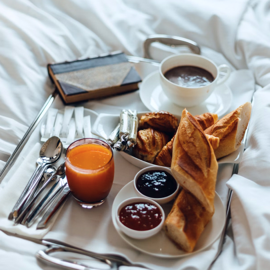 St. Barts villa breakfast in bed: elegant tray with croissants, jams, orange juice, coffee.