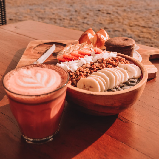 Smoothie bowl and latte on terrace table