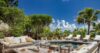 Outdoor lounge and pool at St Barts villa surrounded by palm trees.