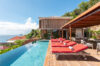 Infinity pool with red loungers at luxury St Barts villa rental overlooking the Caribbean Sea