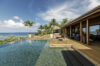 Infinity pool overlooking the Caribbean Sea with wooden deck, palm trees, and open-air lounge at a luxury villa in St Barts.