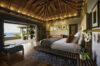 Elegant bedroom with vaulted wooden ceiling, ocean-view terrace, and natural textures at a luxury villa in St Barts
