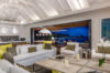 Elegant villa living room in St Barts with modern design, open kitchen, and terrace overlooking the ocean at night