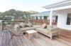 Outdoor deck with modern sofa seating and hillside views at St Barthelemy private villa rental
