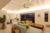 Open-plan living room with colorful sofa and terrace dining overlooking ocean at St Barts villa rental