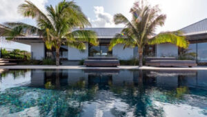 Modern villa with palm trees and reflective pool in Pointe Milou, St. Barts.