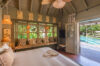 Cozy bedroom at Villa Armancaya with warm lighting, garden views, and direct access to the pool terrace in St Barts
