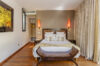 Warm and elegant bedroom with wood floors and soft lighting inside a luxury villa rental in St Barthélemy.