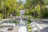 Palm-lined swimming pool and sun loungers leading to the beach at a luxury St Barts villa rental