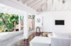 Sunlit living room with white decor and open terrace with hammock at a private villa rental in St Barts