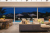 Open-plan living and dining area overlooking the illuminated pool and hillside lights at a St Barts luxury villa rental