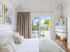 Bright bedroom with terrace access and soft neutral decor at a luxury St Barths villa rental.