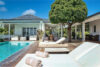 Villa pool deck with lounge chairs, large tree, and covered patio in Mont Jean