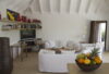 Bright living room with white sofas, art accents, and garden access at Villa Plumbago, St Barts luxury villa rental.