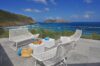 Elegant ocean-view terrace with modern white seating and champagne setup at Villa Plumbago, St Barts villa rental