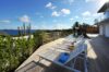 Sunlit terrace with loungers beside infinity pool overlooking the sea at Villa Plumbago, St Barth villa rental