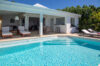 Sunlit pool and terrace at Villa Plumbago, featuring shaded lounge and open living area in St Barts villa rental.