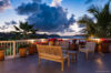Evening terrace with wooden seating and ocean view at Villa Plumbago, Colombier, St Barts villa rentals.
