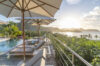 Sunset view over Caribbean Sea from pool terrace with loungers and umbrellas at luxury villa rental in St Barths