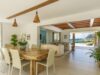 Open-plan dining and living area of a luxury St Barts villa, blending natural wood, tropical greenery, and ocean views.
