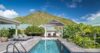 Luxury St Barts villa with private pool, sun loungers, and tropical mountain views surrounded by lush gardens