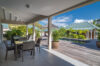 Covered outdoor dining terrace overlooking a private pool and tropical gardens at a luxury St Barts villa.