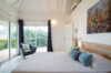 Tranquil bedroom with soft neutral tones, large windows, and garden views at a contemporary St Barts villa rental