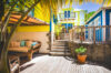 Vibrant Caribbean villa courtyard with sunlit deck, lounge area, and tropical palms in St Barts vacation rentals.