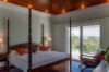 Elegant bedroom with four-poster bed and ocean-view balcony at a St Barts villa rental.