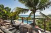 Ocean-view terrace with sun loungers and infinity pool overlooking the bay at a St Barts luxury villa.