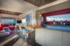 Modern kitchen and living space in st barts villa with red accents, ocean views, and open design