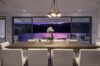 Elegant dining room of st barts villa facing infinity pool and lagoon at twilight with soft ambient lighting.