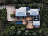 Aerial view of contemporary st barts villa surrounded by lush tropical gardens with pool and wooden deck