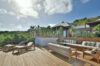 Spacious sun deck of luxury st barts villa with elegant outdoor lounge, sunbeds, and tropical hillside views.