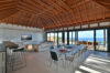 Elegant open-plan living area of contemporary st barts villa with ocean views, vaulted wood ceiling, and modern dining space.