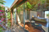 Serene bedroom suite of st barts villa with glass walls opening to tropical garden and private terrace lounge.