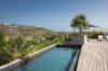 Infinity pool surrounded by tropical gardens and ocean views at st barth villa rental.