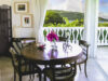 Elegant indoor dining area with balcony view over tropical hills at st barts villa rental.