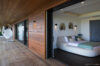 Elegant bedroom opening onto wooden terrace with hanging chair at luxury St Barts villa rental.