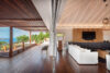 Open-plan living area and terrace at luxury st barts villa with ocean view and wooden design.