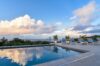 Tranquil infinity pool with sun loungers and ocean views under a pastel evening sky at a St Barts villa rental